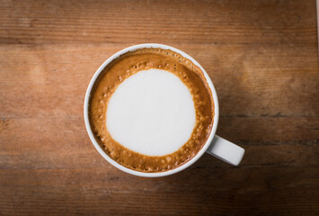 hot coffee with foam milk art, latte art coffee ( Filtered image processed vintage effect.)