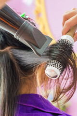 Close up of beautician's hand setting the hair properly after haircut