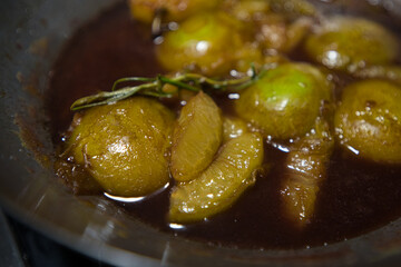 Halbierte Birnen beim kandieren in einer schwarzen Grußpfanne