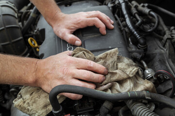 Close-up Of Hand Repairing Car Engine.