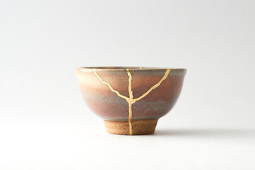 Japanese kintsugi ceramic sake cup, restored with real gold. Antique pottery kintsukuroi.
