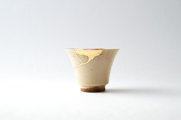Japanese kintsugi ceramic sake cup, restored with real gold. Antique pottery kintsukuroi.
