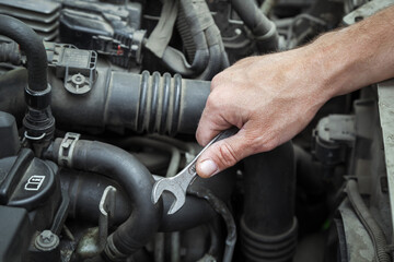 Fototapeta na wymiar Close-up Of Hand Repairing Car Engine.