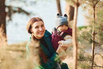 Obraz premium Mother with her little son have a walk in spring forest at daytime