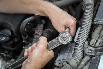 Fototapeta na wymiar Close-up Of Hand Repairing Car Engine.