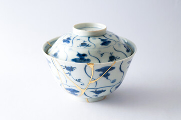 Japanese kintsugi ceramic rice bowl restored with real gold. Antique pottery kintsukuroi.