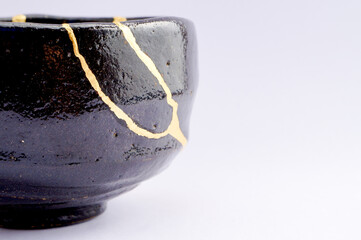 Japanese kintsugi black raku ceramic chawan, restored with real gold. Antique pottery kintsukuroi.