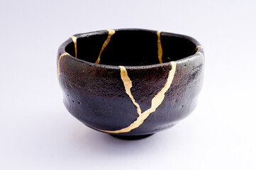 Japanese kintsugi black raku ceramic chawan, restored with real gold. Antique pottery kintsukuroi.