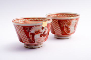 Japanese kintsugi ceramic sake cup, restored with real gold. Antique pottery kintsukuroi.
