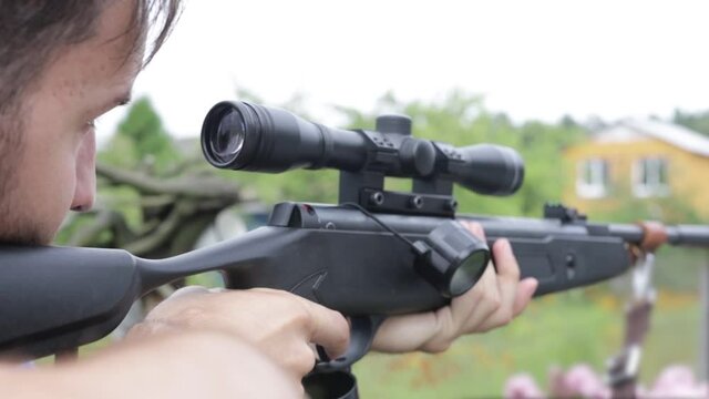 man shoots from a pneumatic sniper rifle in nature. shooting training.