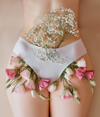 flowers poke out of white cotton underpants. rosebuds of pink and white roses peek out from under...
