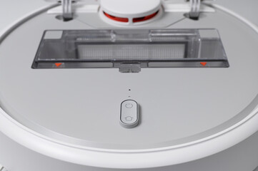 Modern robot vacuum cleaner on gray background flat lay. New technologies, quick house cleaning, automatic robot assistant. Free time to relax. Future technology, smart appliance for cleaning house
