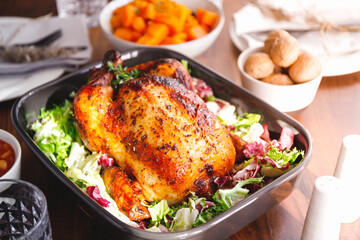 Decorated festive table with whole roasted chicken, salad, pumpkin, mushrooms, beans and walnut. The concept of family dinner or Thanksgiving celebrate