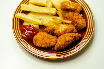 Chicken breast chunks, coated in breadcrumbs with potato chips and ketchup