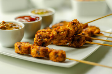 Satay chicken breast marinated in Indonesian style spices and grill on wooden skewers with dip peanut, ketchup, mustard