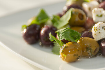 Fresh Greek salad based on green and black olives with pieces of white feta cheese and parsley