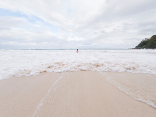 A girl playing with wave in sea water.
