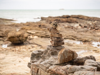 stone stack on beach in Samed, Thailand. cloudy and big waves.
