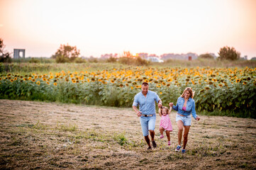 Happy family with a girl having fun in the nature
