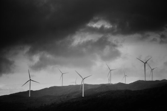 Windfarm in Norway in stormy weather with dark sky in black and white.