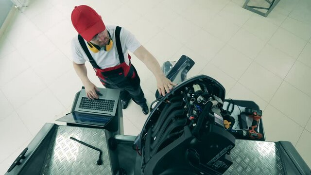 Top view of a boat's engine getting repaired by a maintenance man