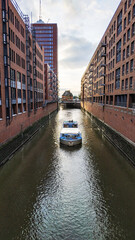 Fototapeta na wymiar The boat goes through a canal in Hamburg