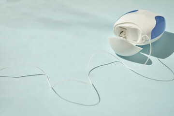 Dental floss on a blue background. Copyspace, topview.