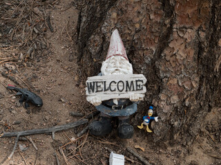 Welcome sign being held by a bearded garden gnome.