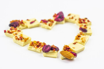 White chocolate with dried berries, fruits and almonds in the shape of a heart.