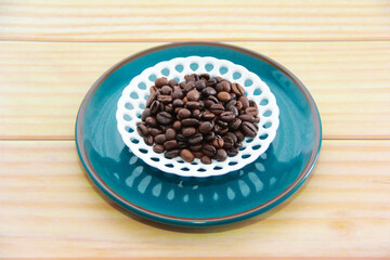 natural brown coffee beans in a decorative plate