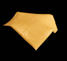 square piece of cheddar cheese isolated on black background, ingredients for sandwich