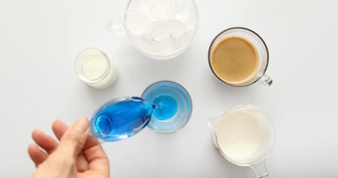 Top view shot of putting blue curacao in glass cup to make blue latte