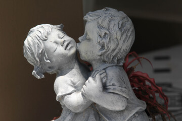 Statue of little children couple are kissing.