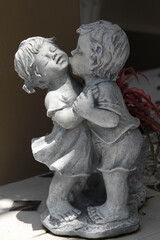 Statue of little children couple are kissing.
