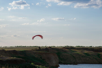 Motorized paraglider in a field above a cliff before takeoff