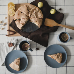 Pieces of delicious apple pie. Composition with tasty homemade apple pie, cinnamon and apples on table. Flat lay. Top view