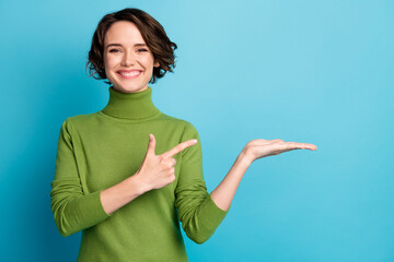Portrait of positive girl promoter point index finger copyspace hold hand demonstrate offer ads...