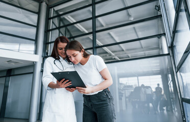 Young woman have a visit with female doctor in modern clinic