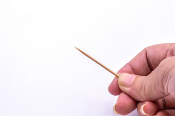 Close up hand holding wooden toothpick isolate on white background.