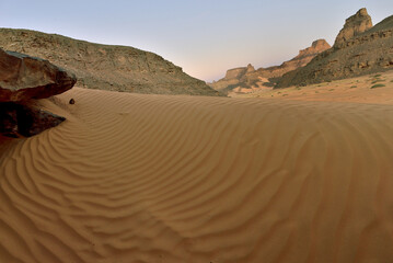 TASSILI TADRART. ALGERIA. SAHARA DESERT LANDSCAPE WITH SAND DUNES AND ROCK FORMATIONS. SAFARI AND TREKKING IN ALGERIA. 