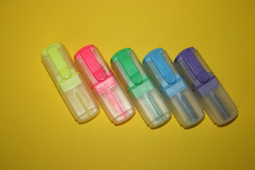 small multicolored markers on a yellow background