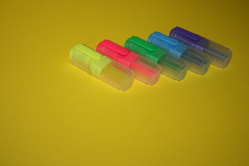 small multicolored markers on a yellow background