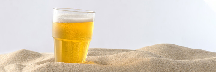 Beach vacation concept. Cool drinks on the beach sand. Cold foamy beer. Banner. Close-up.
