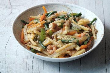 Fresh homemade salad in a plate with dumbbell on table 