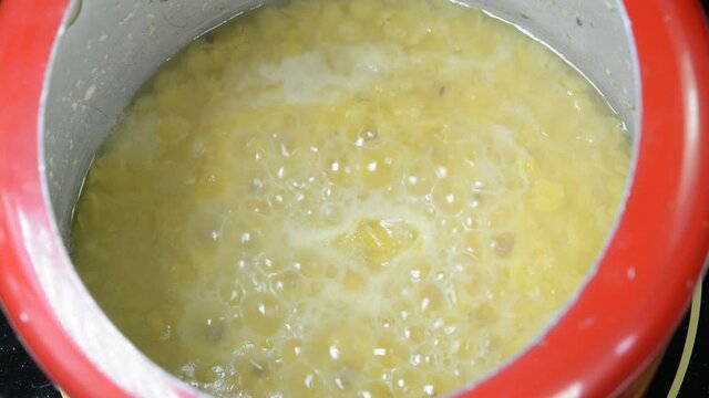 Cooking split pigeon peas in a pressure cooker. They are also called as Toor Daal in India.