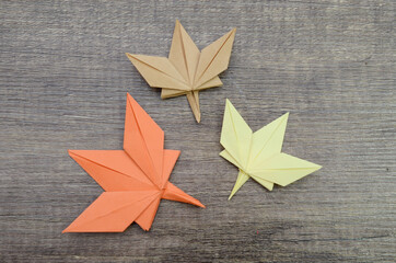 Autumn paper origami maple leaf on wooden