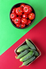 Fresh cucumbers and tomatoes in wooden bowls against the multicolored geometric background