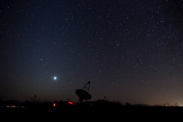 A large parabolic telescope peering into the night sky