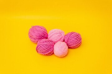 lilac, pink balls of wool lie on a yellow background