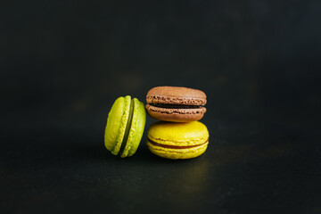 Tasty french macarons in a box on a dark background.